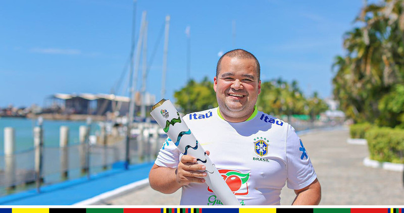Ricardo Sales poses for photo with the Olympic flame