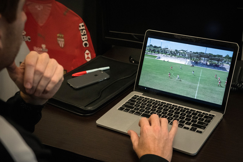 Analyst watches soccer video on laptop