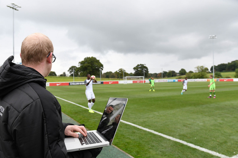 Man analyses soccer from sidelines