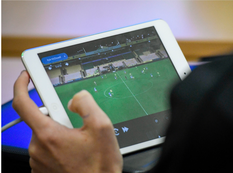 Pessoa assistindo a vídeos de partidas de futebol em um tablet